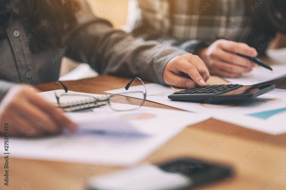 Closeup image of a businessman using calculator in a business meeting Closeup image of a businessman using calculator in a business meeting