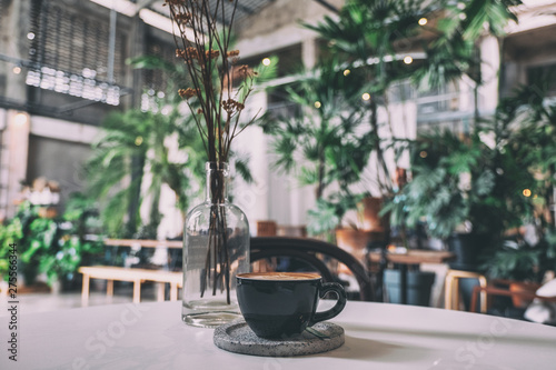 A black cup of hot coffee on table in cafe