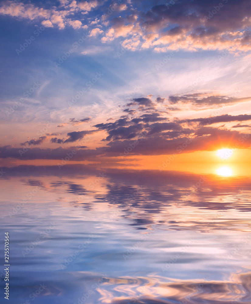 Heavenly sunset with the rays of the sun in the blue sky over the quiet, calm sea. Heavenly sunset with the rays of the sun in the blue sky over the quiet, calm sea.