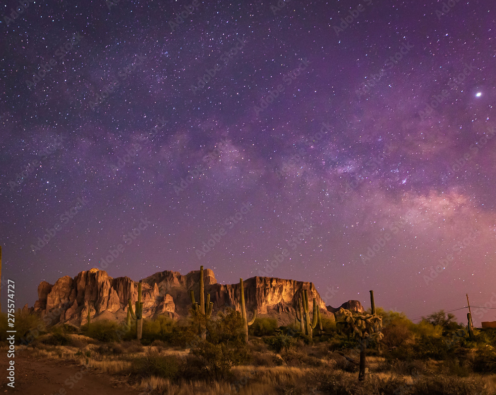 The iconic Superstition Mountains east of Phoenix, Arizona glow under the desert  night sky and the
