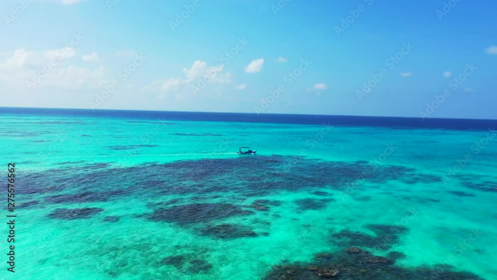 Fly over turquoise water with reefs inside. Towards an over a blue motorboat. Dolly in in Jamaica Fly over turquoise water with reefs inside. Towards an over a blue motorboat. Dolly in in Jamaica