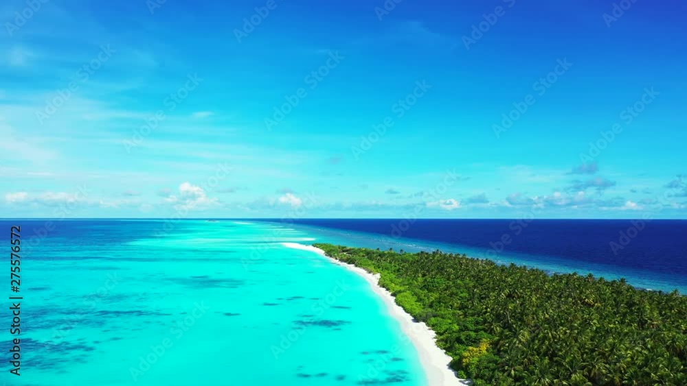 Drone view. Flight next to an exotic island with a forest on it. Turquoise water of the sea in Indonesia. Dolly out. A blue sky above Drone view. Flight next to an exotic island with a forest on it. Turquoise water of the sea in Indonesia. Dolly out. A blue sky above