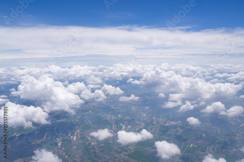 Beautiful scenery of sky, white clouds and land looking from window on airplane. Space for text