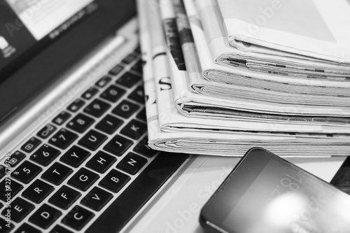 News. Newspapers, Laptop and Smartphone - Sources of Information. Finance Magazines and Journals Stacked in Pile on Keyboard of Computer. Business Concept 