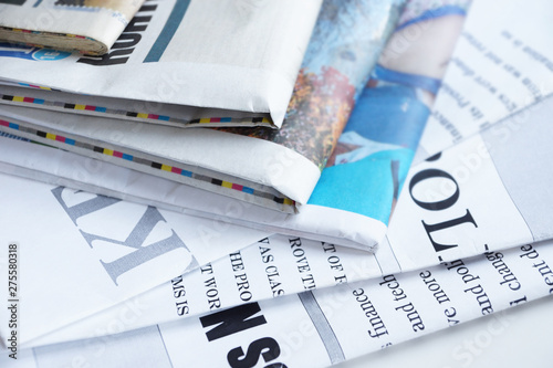 Lots of Newspapers Stacked in Pile and News Pages with Headlines and Articles Scattered on Table. Business Magazines with Financial Information, Paper Media for Planning and Analysis. Business Concept