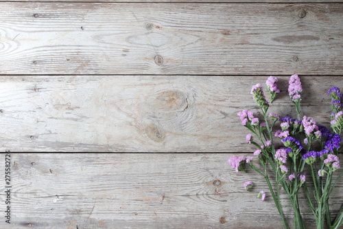 Pink flowers on table wooden background.Copy space for text on wood texture