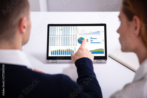 Businessman's Hand Pointing Laptop Screen Showing Bar Graph