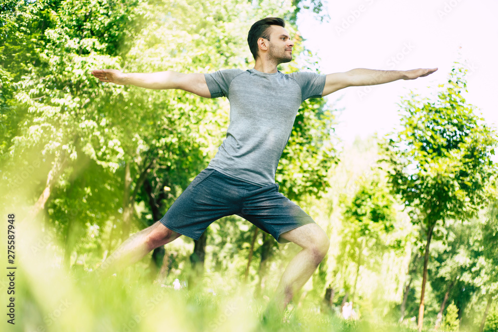 Male yoga relaxation. Sporty and slim handsome young man is doing yoga exercises in city park outdoors. Healthy lifestyle and strong soul and body Male yoga relaxation. Sporty and slim handsome young man is doing yoga exercises in city park outdoors. Healthy lifestyle and strong soul and body