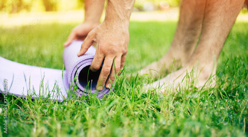 Soft focus image of preparation for yoga exercises. Practicing yoga or Pilates outdoors. Restore your concentration, energy by doing few stretches in park. Soft focus image of preparation for yoga exercises. Practicing yoga or Pilates outdoors. Restore your concentration, energy by doing few stretches in park.