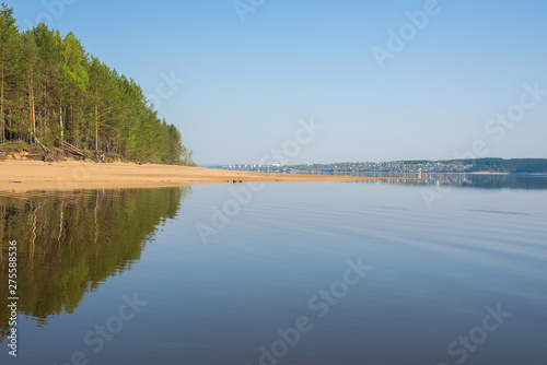 River  Kama The sandy beach is a pine forest reflected in the water.