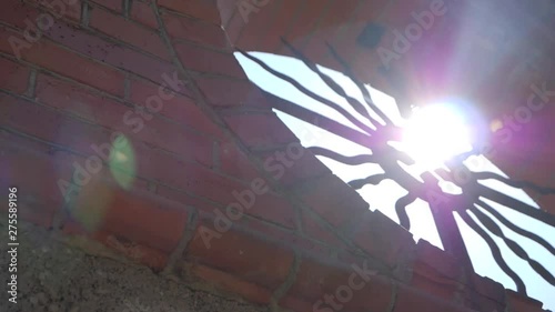 Sunlight streaming though a pagan cross located in a brick wall. SLOW MOTION