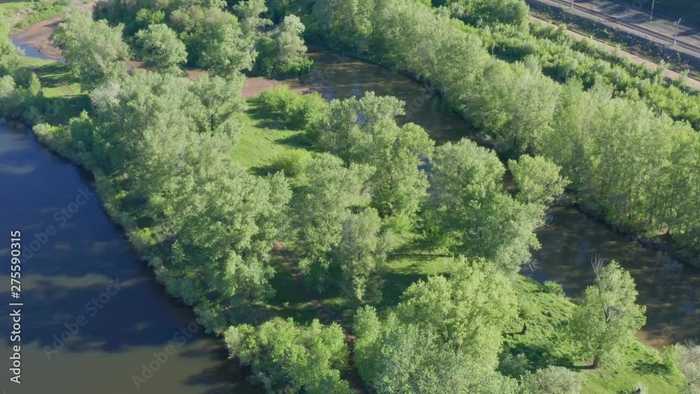 Aerial shot of the river. Shooting on a sunny summer day. next to the river is a small lake. Around grow a lot of trees. Nearby is the railway. Aerial shot of the river. Shooting on a sunny summer day. next to the river is a small lake. Around grow a lot of trees. Nearby is the railway.