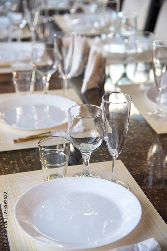 Table setting in the restaurant, including glasses for wine, champagne and cognac, napkins and plates for guests
