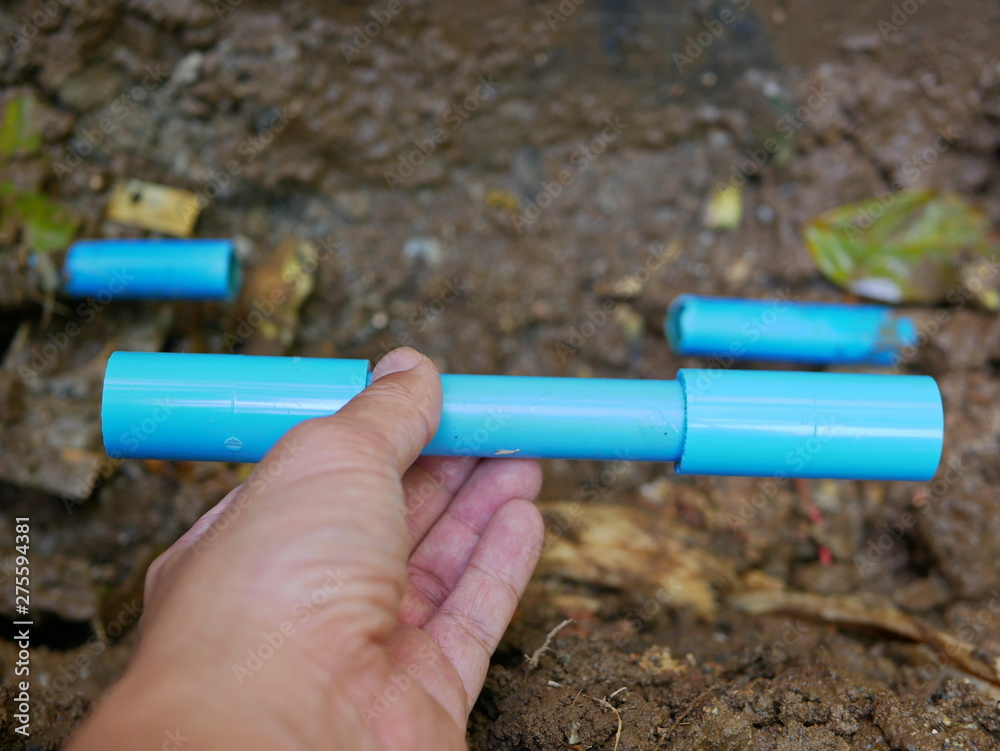 Selective focus of broken / leaked / cracked PVC water pipe underground is about to be fixed by replacing the cut-off part with new pipes Selective focus of broken / leaked / cracked PVC water pipe underground is about to be fixed by replacing the cut-off part with new pipes