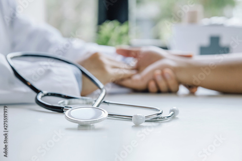 Stethoscope and background hand of doctor reassuring male patient