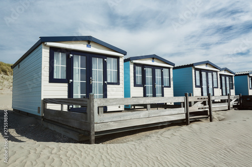 Row of White Beach Houses on a Sandy Shore © ptnphotof