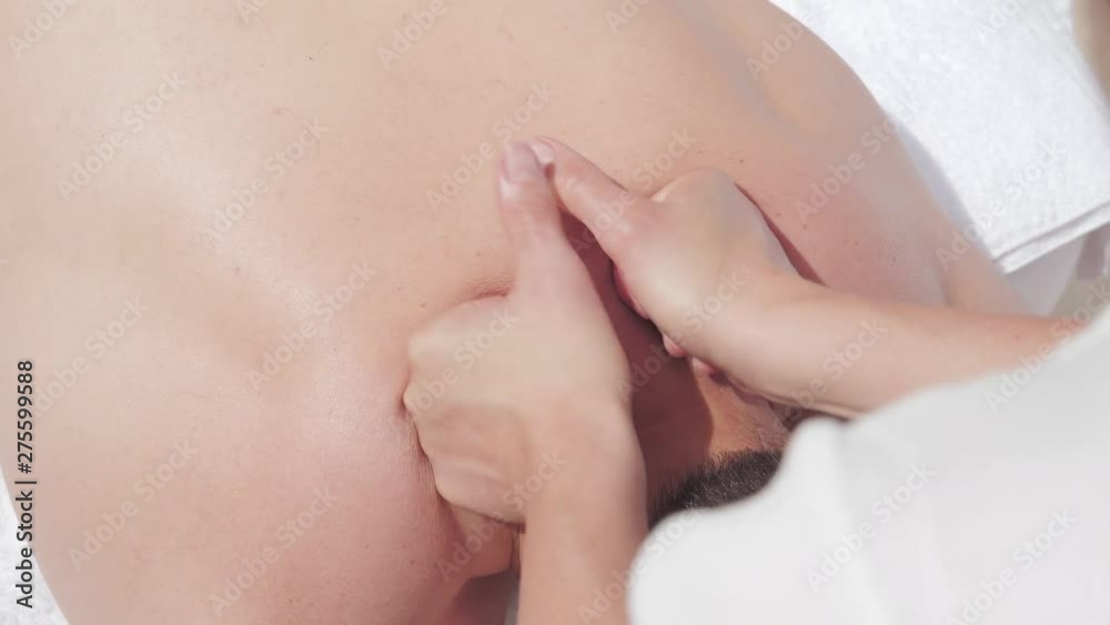 Personal masseuse woman apply pressure alongside man vertebrae and spine in a luxury spa environment. Personal masseuse woman apply pressure alongside man vertebrae and spine in a luxury spa environment.