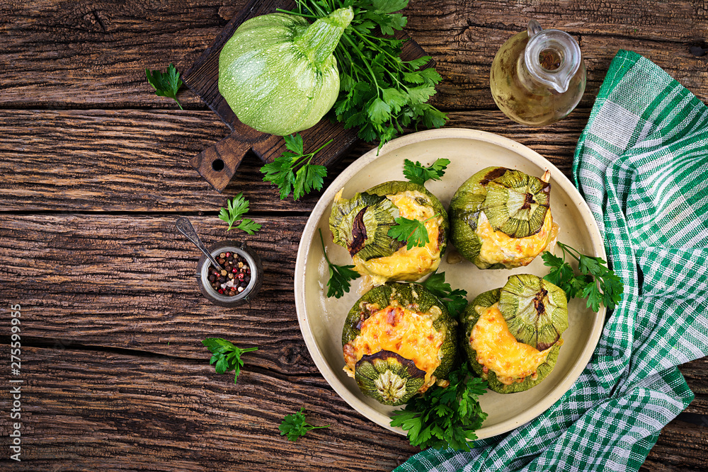 Zucchini stuffed with minced meat, cheese and green herbs. Baked in oven. Top view