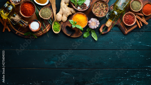 Fototapeta Naklejka Na Ścianę i Meble -  Large spice and herb collection in bowls and spoons. Indian spices. On a black wooden background. Top view.