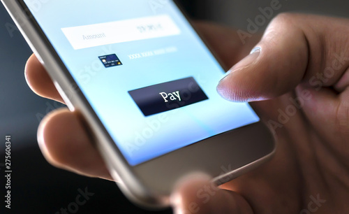 Mobile payment with wallet app and wireless nfc technology. Man paying and shopping with smartphone application and credit card information. Digital money transfer, banking and e commerce concept. photo