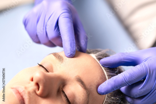 Cosmetologist, plastic surgeon or doctor with patient or customer. Consultation and plan before facial surgery in hospital, skin treatment or facelift in clinic. Professional skincare in beauty salon. photo