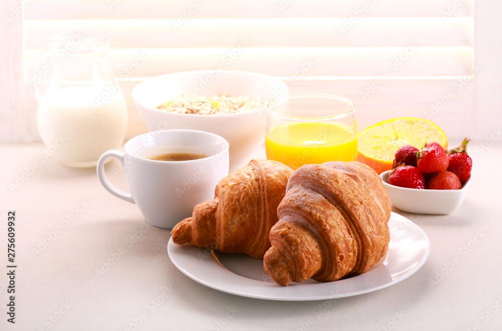 Breakfast with croissant, orange juice, and coffee served