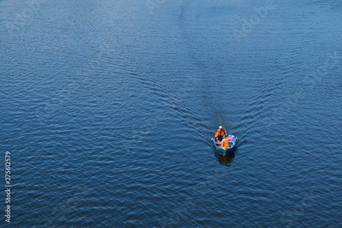 Top view of the boat with two people on the river.