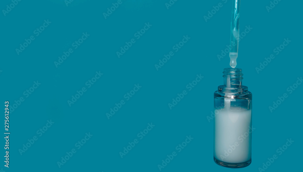 glass bottle with pipette on a blue background isolate glass bottle with pipette on a blue background isolate