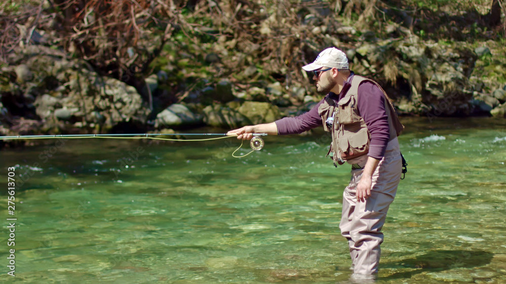 Flyfish fisherman fishing for fishes in stream river Flyfish fisherman fishing for fishes in stream river
