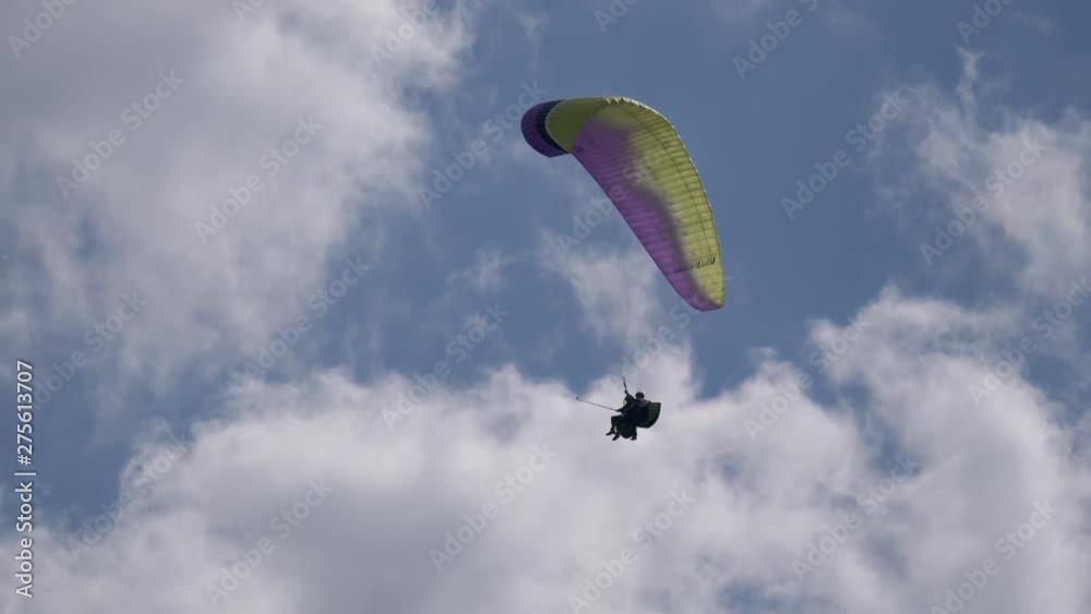 Two paraglider tandem fly against a cloudy sky Two paraglider tandem fly against a cloudy sky