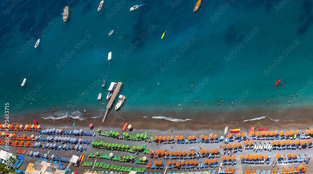 Aerial View of Positano Beach. Beautiful cliff view of Positano beach at daytime, with its beach umbrellas. Amalfi coast situated in province of Salerno, in the region of Campania, Italy.