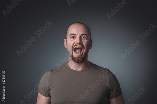 portrait of caucasian man screaming and looking straight in front of the camera