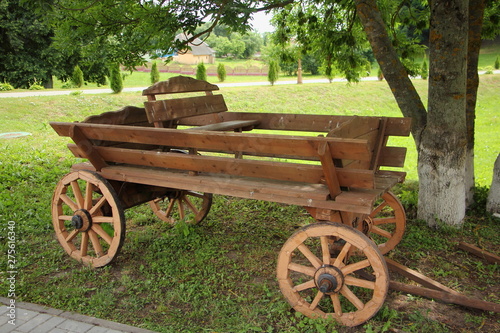 Russian rustic retro transport - vintage horse cart on wooden spoked wheels in the Park on a summer day