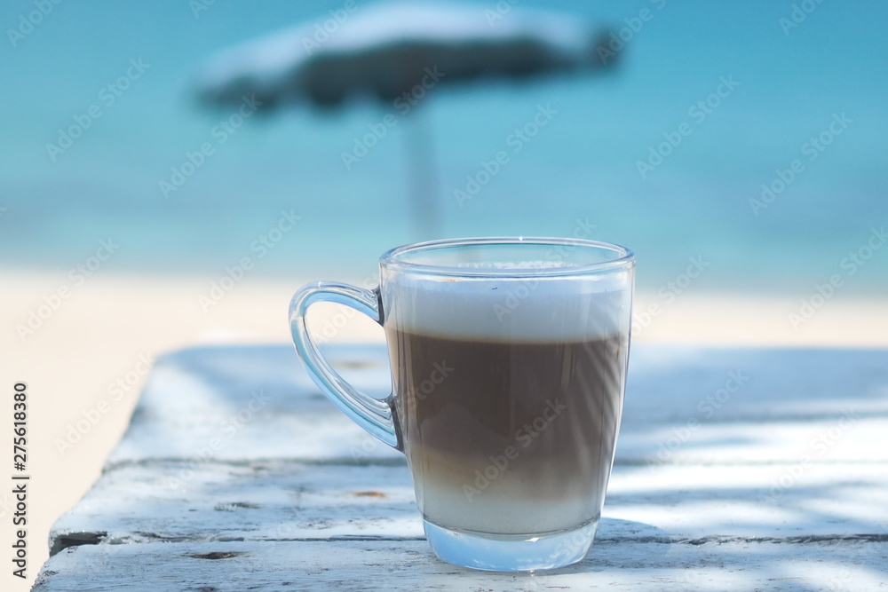 Hot coffee on a wooden table, sea view.