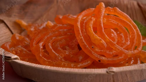 Delicious jalebis are served in a plate that is rotating. Jalebi is a very famous Indian dessert that is served during festivals, weddings and  parties.
