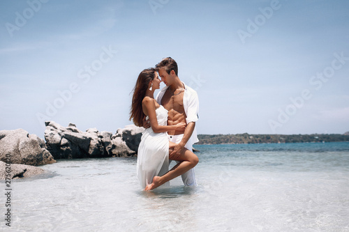 romantic young couple in white clothes enjoying summer vacation on the beach. Passion. Phuket. Thailand.