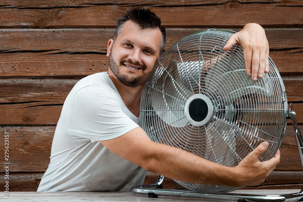A sweaty man hugs a cooling ventilator, refreshing in the concept of a hot  summer. The concept of salvation from the heat, hot weather, a primitive  air conditioner Stock Photo | Adobe