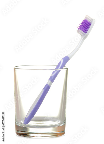 Multi-colored toothbrushes in a glass beaker on a white isolated background. Oral hygiene.