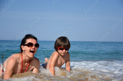 Mother and son enjoying on beach. Happy family relax on sea on summer vacation