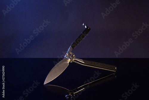 Balisong knife on a dark background. Balisong knife in the open position.