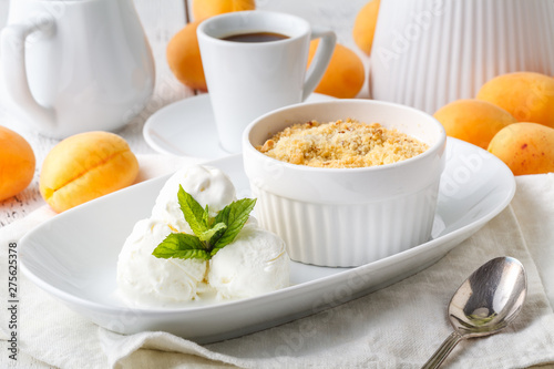 Bowl with apricot crisp crumb and ice cream on table