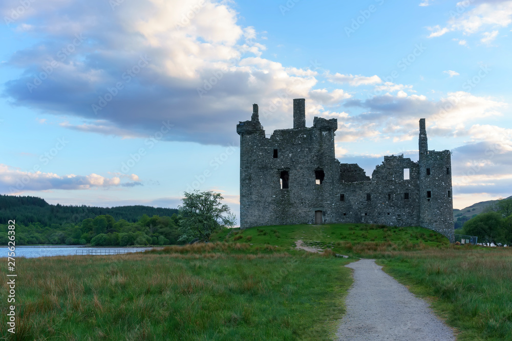 Kilchurn Castle , in the care of Historic Environment Scotland , is a ruined structure on a rocky peninsula at Loch Awe in twilight , Argyll and Bute, Scotland