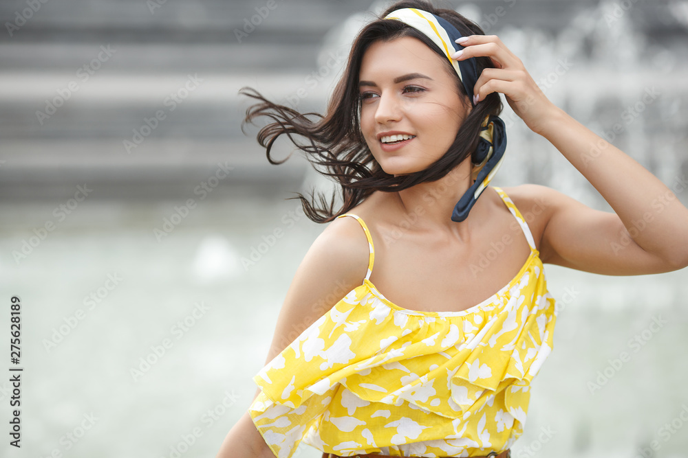 Attractive young woman wearing kerchief in her hair. Stylish female with accessories. Woman beauty portrait outdoors. Attractive young woman wearing kerchief in her hair. Stylish female with accessories. Woman beauty portrait outdoors.