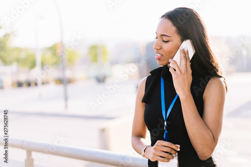 Beautiful businesswoman speaking on phone on street