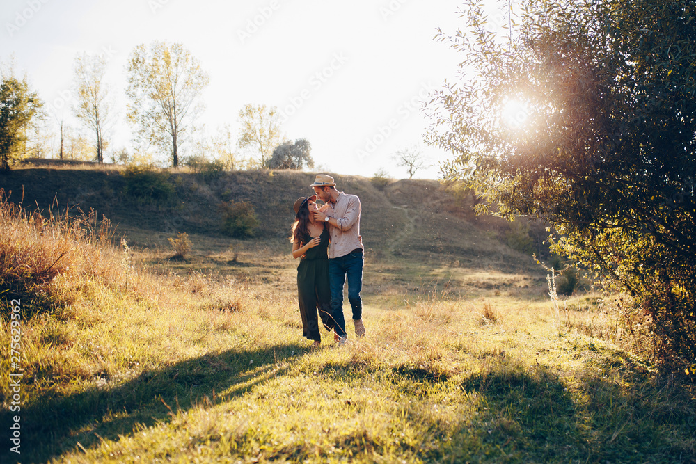 Couple in love having romantic tender moments at sunset on the park . Love, holidays and travel concept - Soft focus on them. Place the text.