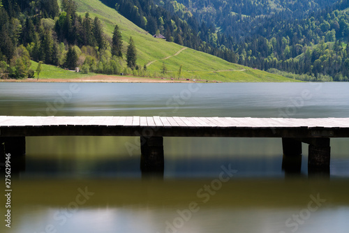 long wooden boardwalk on a calm and placid mountain lake with a great view