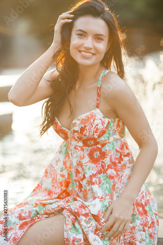 Beauty portrait of woman outdoors. Attractive stylish young female near the fountain in summertime.Closeup portrait of cheerful girl.