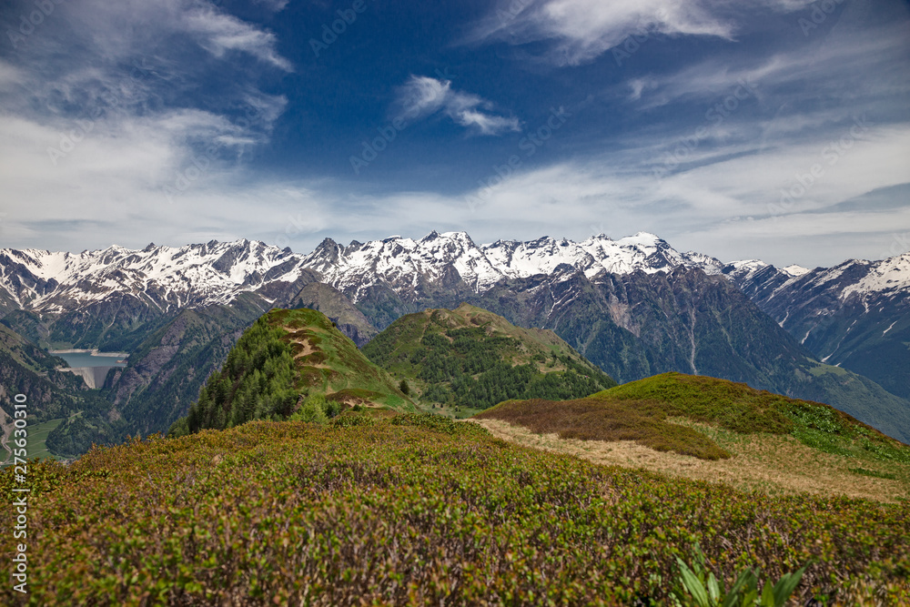Fototapeta premium Panoramic view of the snow-capped peaks of the Alps in the upper Blenio valley in Switzerland, in spring.