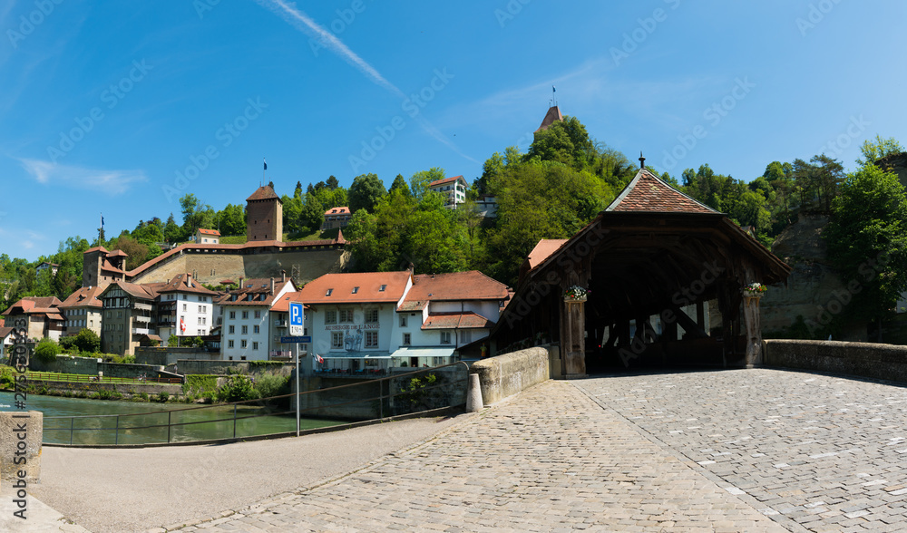 view of the historic Place de Jean-Francois-Reyff Square and Bernbruecke covered bridge in the old town of the Swiss city of Fribourg view of the historic Place de Jean-Francois-Reyff Square and Bernbruecke covered bridge in the old town of the Swiss city of Fribourg