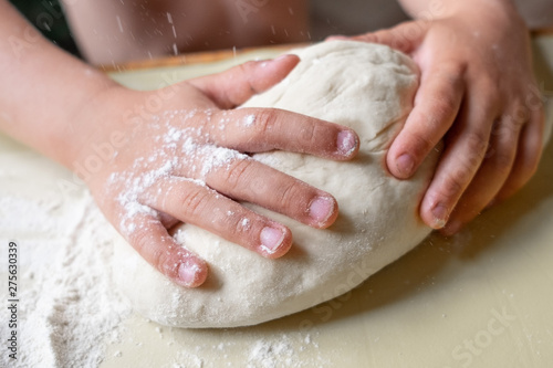 Closeup portrait of kids and adult hands making dough for pastry 